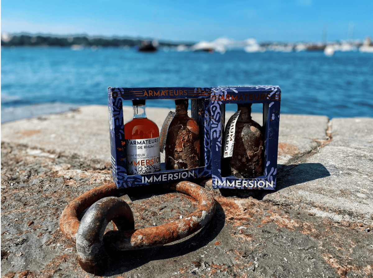 Coffret Rhum Armateurs Immersion posé sur ancre – rhum breton vieilli sous mer.